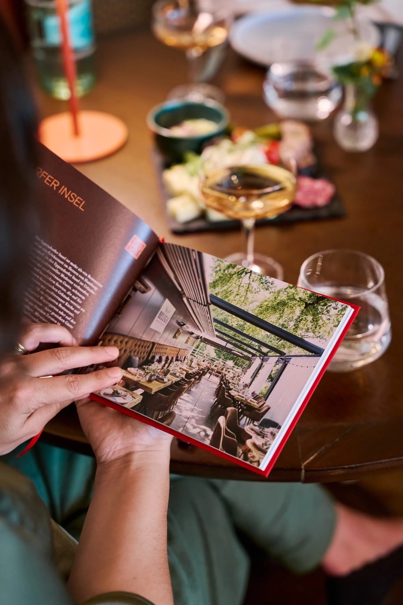 Gast blättert im TasteTwelve-Buch am gedeckten Tisch