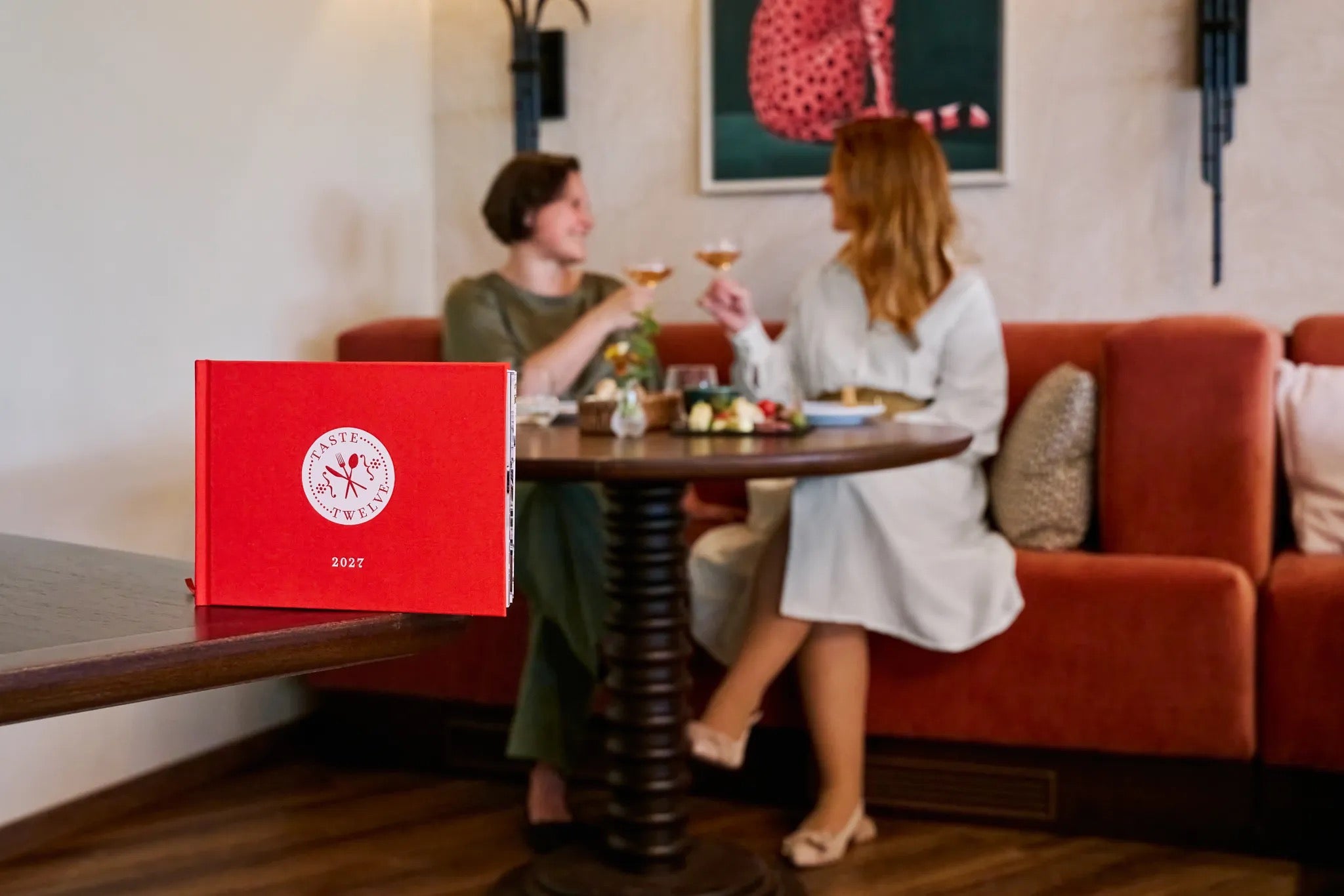 TasteTwelve 2027 auf dem Tisch, Gäste im Hintergrund