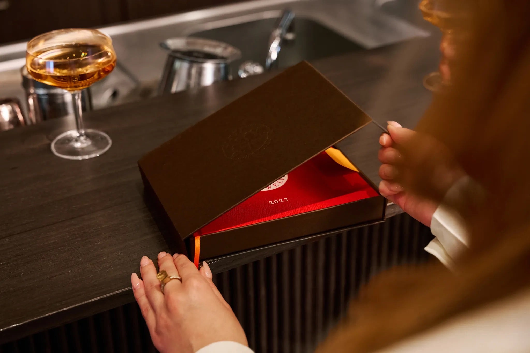 Geschenkbox wird geöffnet, TasteTwelve 2027 darin